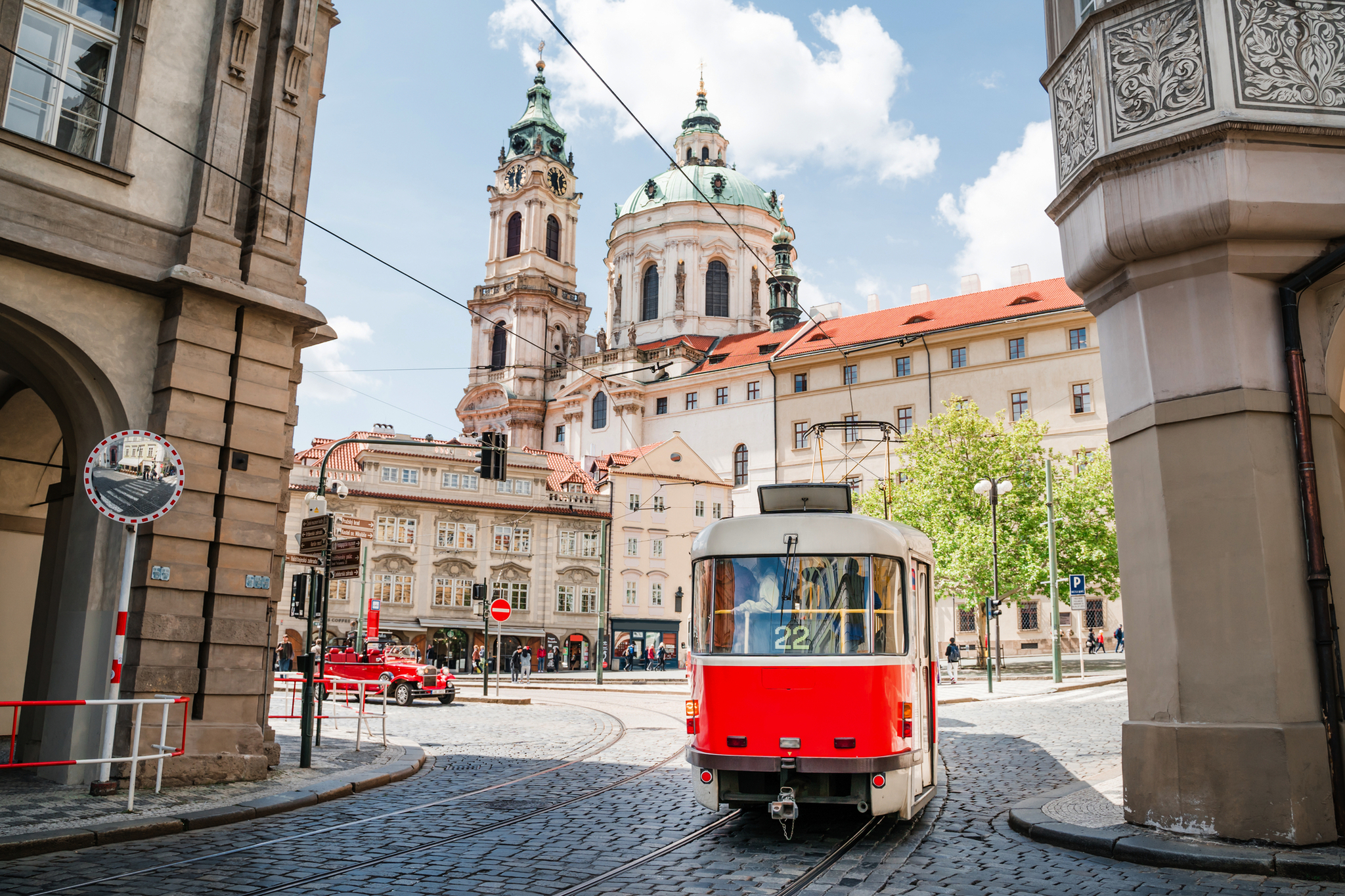 Rote Straßenbahn in den Straßen der Altstadt von Prag Rote Straßenbahn vor historischer Kirche in einer europäischen Stadt.